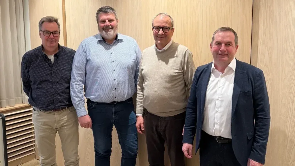 Vier Vertreter von Au2mate und ZewaTec Automation vor einer Holzwand