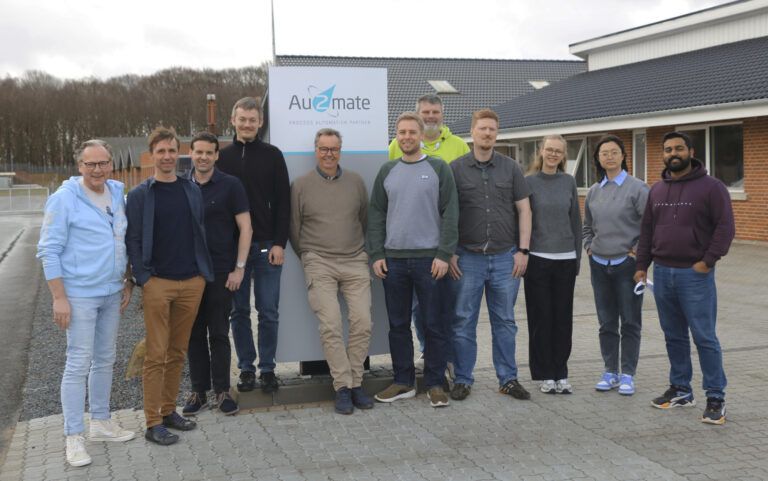 Gruppenfoto der Teams von ZewaTec Automation und Au2mate vor dem Au2mate-Schild in Silkeborg